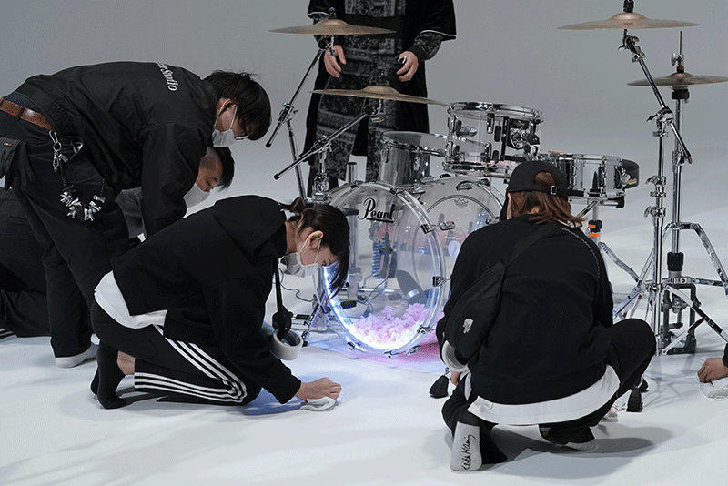 床をキレイに磨いている学生たち。Pearlのドラム クリスタルビートに桜の花びら入ってます