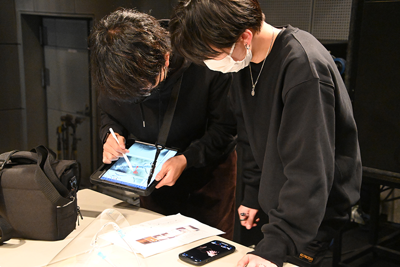 撮影するカットを確認しながら進行するディレクターとカメラマン