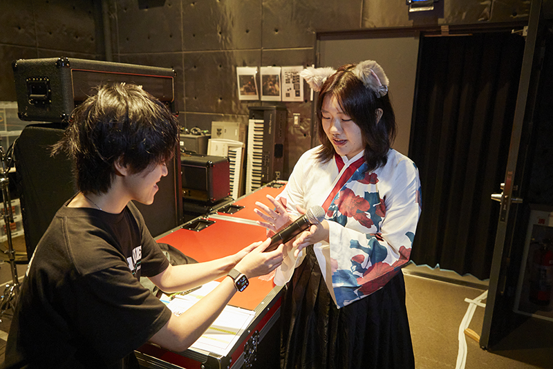 舞台袖では、音響技術科の学生がdreaming catsのメンバーにマイクを渡す場面も！